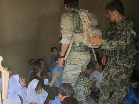 Příslušníci afghánské armády při předávání školních pomůcek ve smíšené třídě v provincii Parwan.