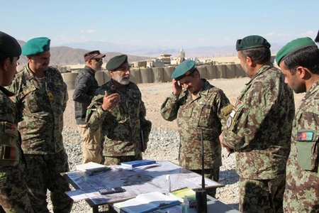 Náčelník dělostřelectva 4. brigády ANA major Andul Motalab (čtvrtý zprava) hovoří s afghánskými dělostřelci.