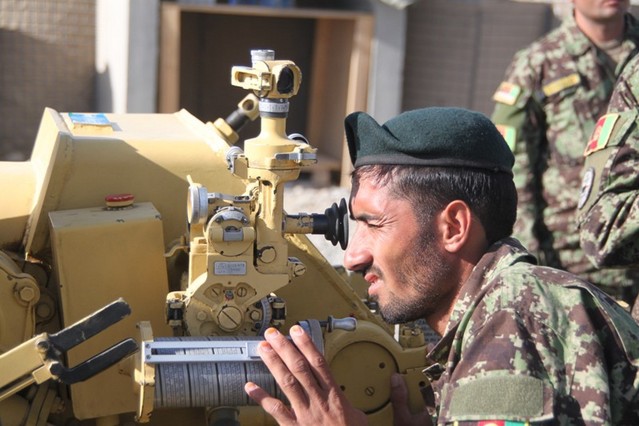 Afghánský dělostřelec kontroluje nastavení prvků pro střelbu.