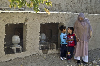 Afghánská žena spolu s dětmi u hliněného kurníku se slepicemi od Provinčního rekonstrukčního týmu Lógar.