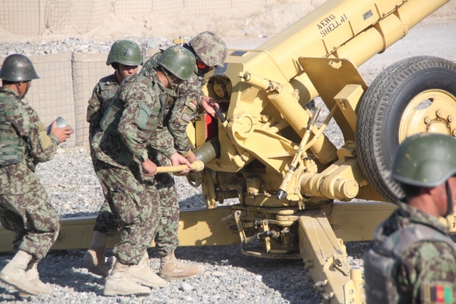 Afghánští dělostřelci nabíjí 122 mm dělo D 30, do kterého používá tzv. dělené střelivo. Vpravo vidíte granát při zasouvání do hlavně. Voják v levé části snímku drží nábojku.