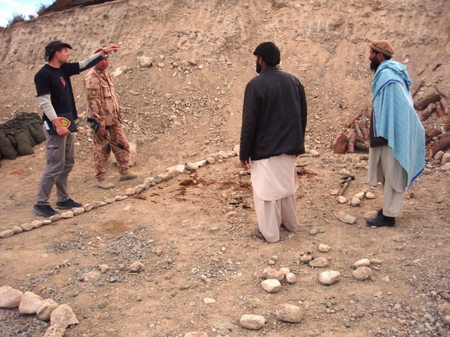 Stavební inženýr civilní části českého provinčního rekonstrukčního týmu Lógar Jan Pivec upřesňuje afghánským stavařům detaily připojení odpadního potrubí do septiku.
