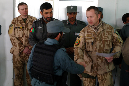 Pukovník Genser gratuluje novému afghánskému policistovi k završení kurzu