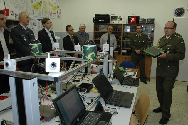 Podplukovník Túró seznamuje přítomné s vybavením laboratoře