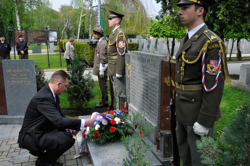 Státní tajemník Petr Vančura rovná stuhy na smuteční kytici u pomníku letců RAF