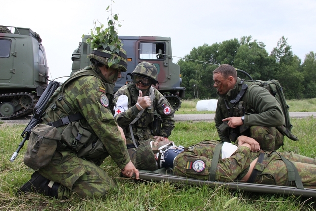 Zdravotník si přebírá zraněného a vydává poslední pokyny před jeho naložením do vrtulníku. 