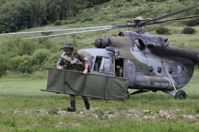 Zdravotník se blíží k raněnému vojákovi. 