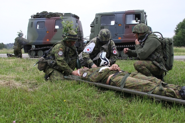 Zdravotník si přebírá zraněného litevského vojáka. 
