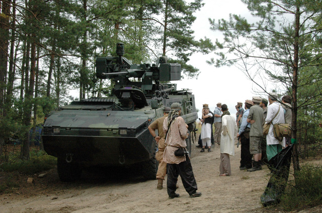 Vesničané z Asmaru okukují Pandur, který přijel v rámci hlídky v konvoji vojenských vozidel