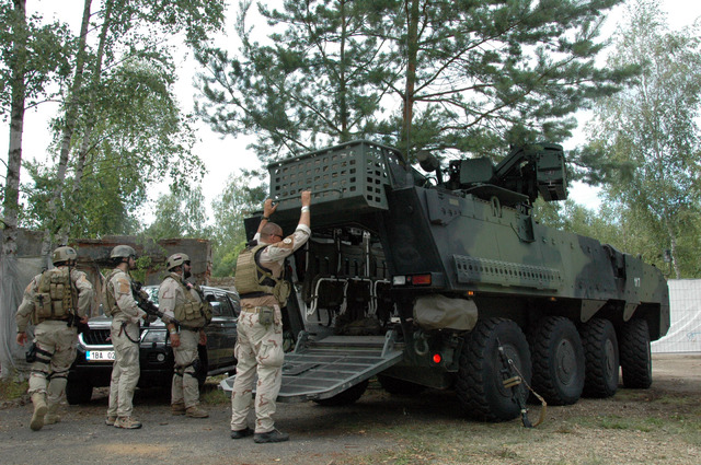 Vojáci v uniformách sil ISAF si zvědavě prohlížejí OT Pandur