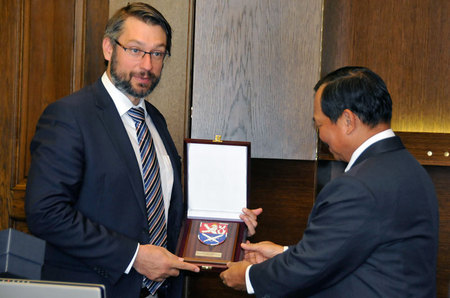 Náměstek pro řízení sekce obranné politiky a plánování Jakub Landovský předává pamětní plaketu vedoucímu filipínské delegace