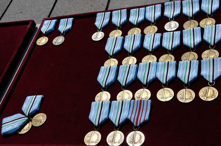 Medaile ministra obrany Za službu v zahraničí - Afghánistán a jedna z nich s červenými proužky je Za službu v zahraničí - bojová zahraniční operace - tu obdržel kapitán Pavel Vystrčil