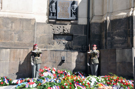 Chodník pod pamětní deskou, která připomíná hrdinnou smrt československých parašutistů v pražské Resslově ulici, zaplavily smuteční věnce a kytice