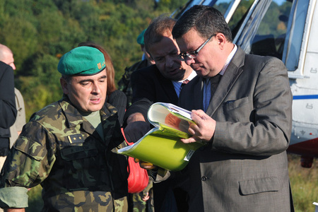 Ministr obrany si krátce po přistání vrtulníku upřesňuje program návštěvy v doupovském výcvikovém prostoru s Vladimírem Kazatelem a pplk. Petrem Vašíčkem