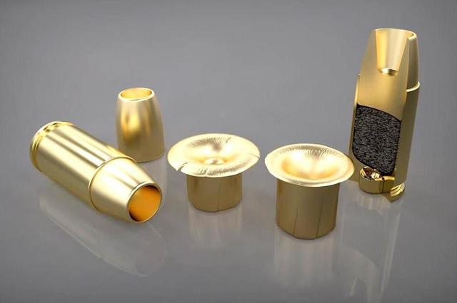 Náboje 9 mm AM – vlevo se střelou, vpravo v řezu, uprostřed dvě expandované střely po průniku etalonovými terči nahrazujícími trup a hlavu člověka