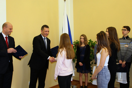 Státní tajemník Petr Vančura předává diplomy Zuzaně Filipovské, Martině Gajdošové a Natálii Petře Havlové za společnou práci