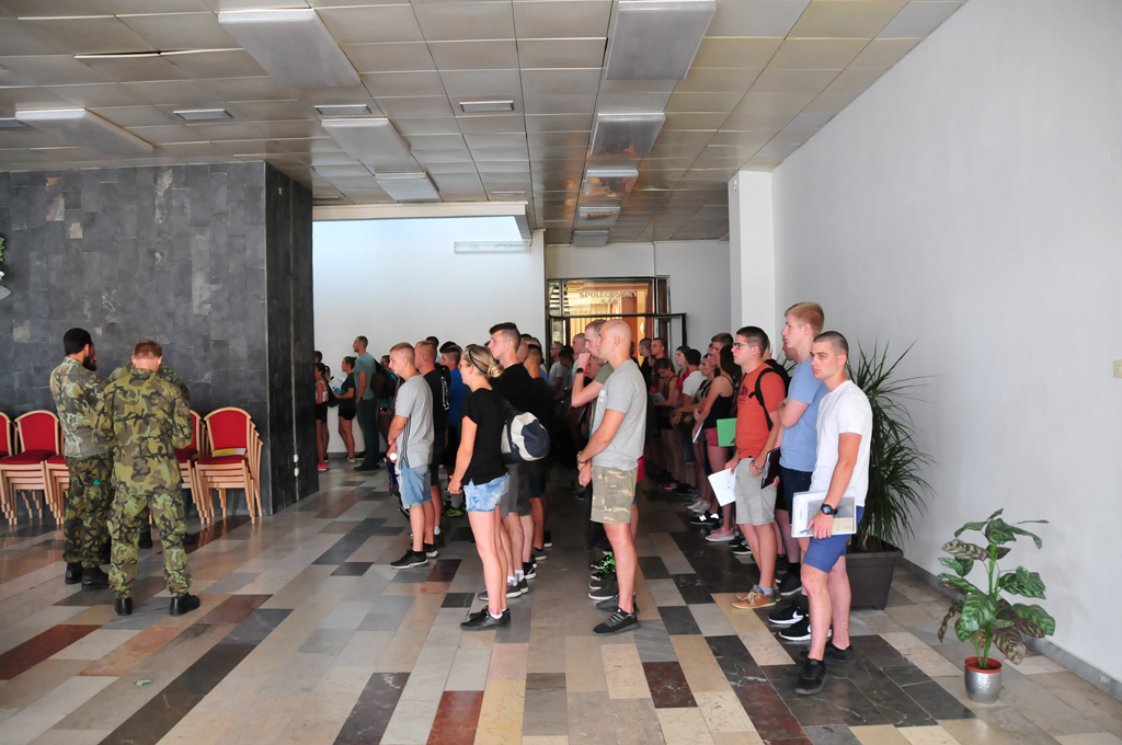 Po vyřízení administrativních záležitostí, lékařské prohlídce, a vybavení jídlem a pitím odchází první z čet do výstrojního skladu