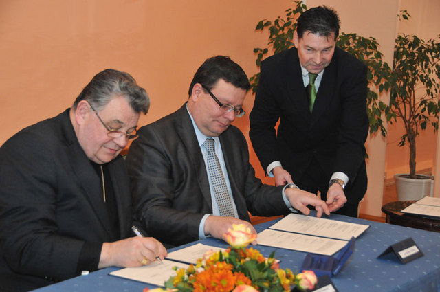 Kardinál Dominik Duka a ministr obrany Alexandr Vondra připojují podpisy pod poslední dodatek Dohody o spolupráci mezi MO ČR, Ekumenickou radou církví a Českou biskupskou konferencí