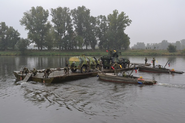 Pontonová mostová souprava s naloženou technikou odplouvá k druhému břehu