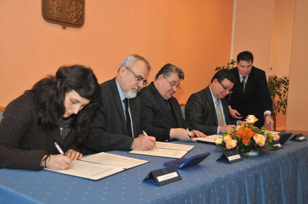 Představitelé církevních organizací - zleva Mgr. Sandra Silná, synodní senior Českobratrské církve evangelické a předseda Ekumenické rady církví v České republice Joel Ruml, Kardinál nominatus J.E, Dominik Duka a ministr obrany Alexandr Vondra podepisují dodatek dohody