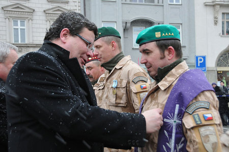 Ministr obrany Alexandr Vondra předává vyznamenání kaplanu jednotky