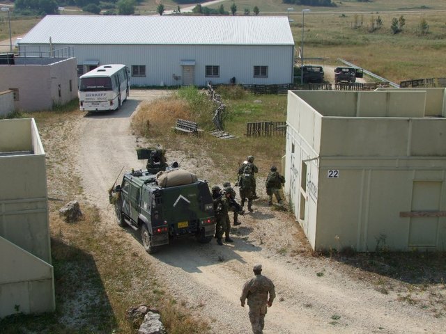  Vojáci dobývají dům za domem pod přísným dohledem