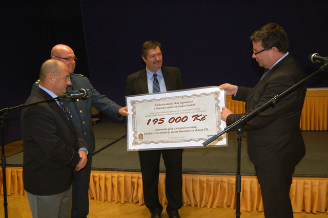 Šek na 195 000 Kč předávají ministru Alexandru Vondrovi Emil Cigánik, pplk. Aleš Krkoška a Pavel Budínský