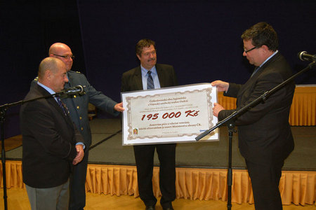 Šek na 195 000 Kč předávají ministru Alexandru Vondrovi Emil Cigánik, pplk. Aleš Krkoška a Pavel Budínský