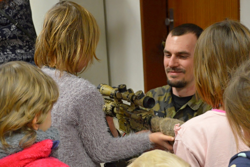 Policista ukazuje dětem jednu ze zbraní