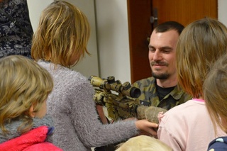 Policista ukazuje dětem jednu ze zbraní