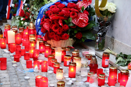 Hořící svíce pod pamětní deskou na Národní třídě