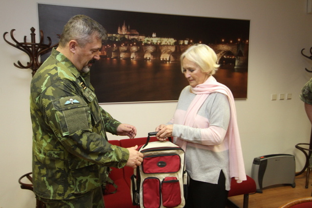 Jednu z tašek symbolicky převzal na kbelském letišti od prezidentky stonožkového hnutí Běly Gran Jensen zástupce náčelníka GŠ AČR – ředitel SOC generálmajor Aleš Opata