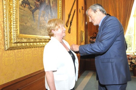 Ministr obrany Martin Stropnický připíná Marii Karáskové Záslužný kříž 