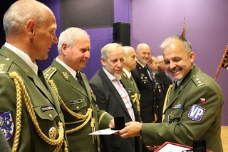 Podplukovník Tomáš Vokálek předává pamětní minci prvnímu náčelníkovi VP Jiřímu Šrámkovi