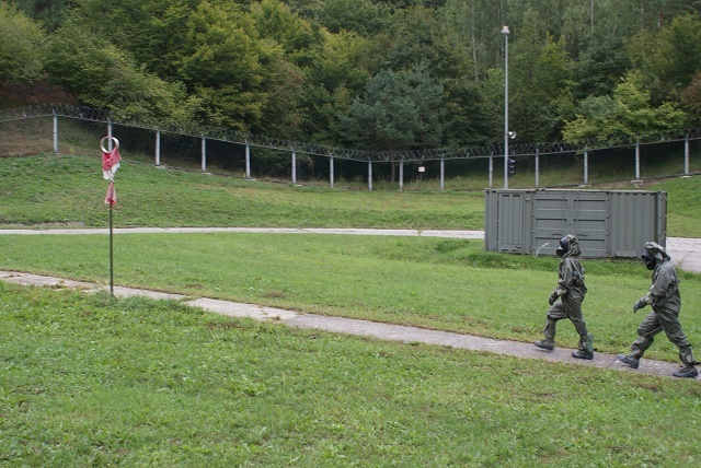 Cvičící v ochranné masce OM-90 a ochranném protichemickém oděvu OPCH-05