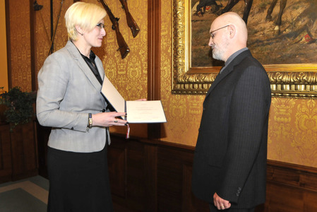 A předává mu jmenovací dekret prezidenta republiky