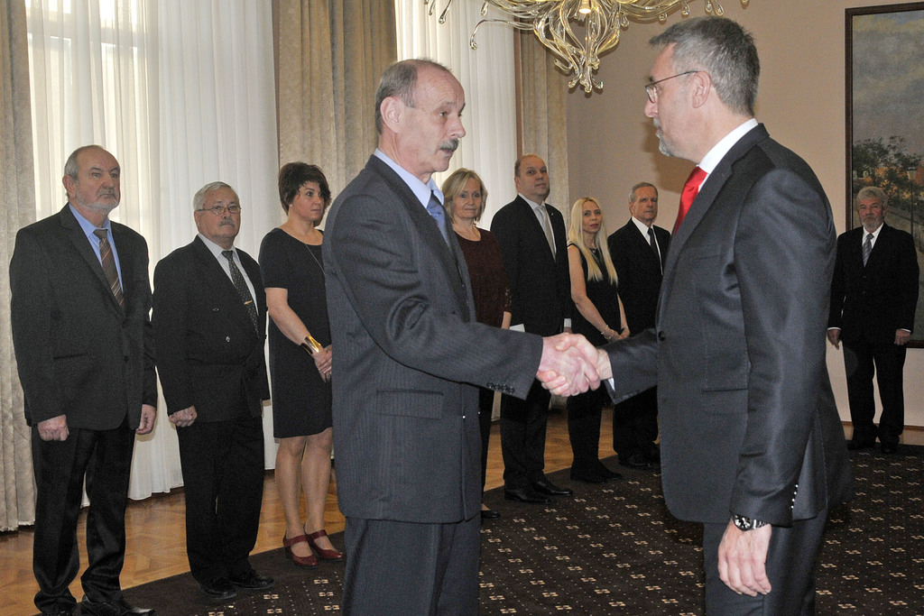 Ministr Lubomír Metnar předává děkovné listy zaměstnancům. 