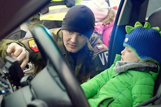 Chlapec si prohlíží vnitřek služebního auta vojenských policistů