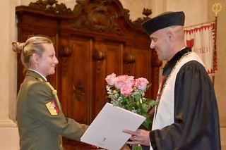 Nadporučice Nikola Hájková dostává ocenění od biskupa Davida Tonzara za navázání spolupráce Vojenské policie s Dětským centrem Srdíčko