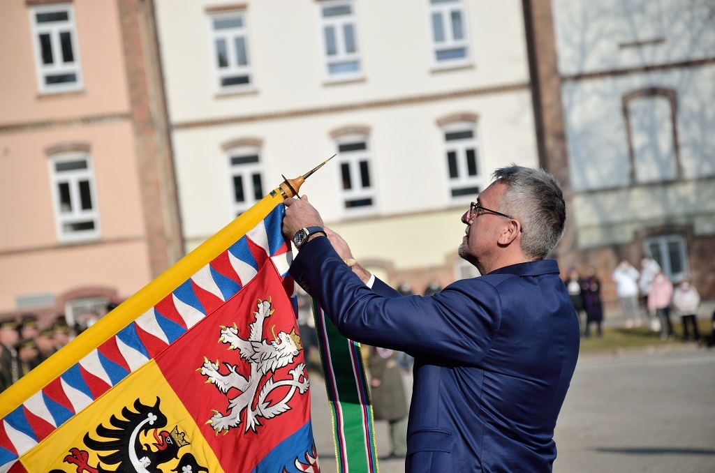 Ministr obrany Lubomír Metnar dekoruje bojový prapor školy stuhou k záslužnému kříži MO