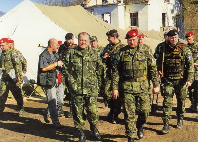Ministr obrany Vilém Holáň navštívil české vojáky v únoru 1996. Na logistické základně v Bosanské Krupě ho doprovází velitel praporu plukovník Josef Sedlák.