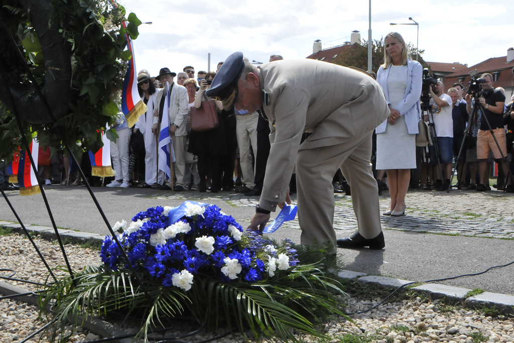 Předseda Vojenského výboru NATO Air Chief Marshal Sir Stuart Peach upravuje stuhu na věnci