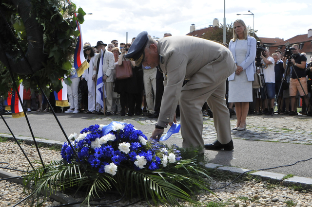 Předseda Vojenského výboru NATO Air Chief Marshal Sir Stuart Peach upravuje stuhu na věnci