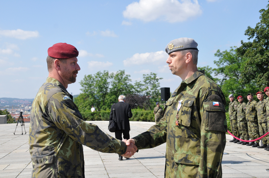 Zástupce ředitele Společného operačního centra MO plukovník gšt. Radek Šíba blahopřeje kapitánu Jiřímu Chudáčkovi k udělení Čestného odznaku Armády České republiky Za zásluhy III. stupně