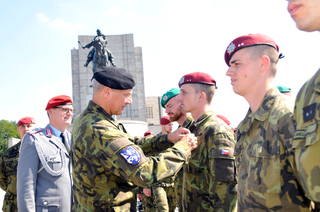 Náčelník Vojenské policie plukovník gšt. Miroslav Murček předává Medaili ministra obrany ČR Za službu v zahraničí jednomu z navrátilců