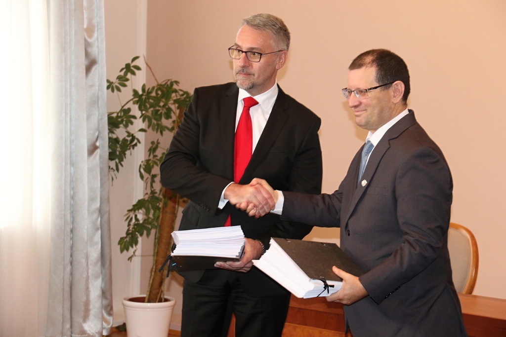 Ministr obrany a ředitel SIBAT si předávají podepsané texty smlouvy