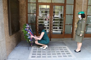 Náměstkyně Blažková rovná stuhy na věnci u budovy Českého rozhlasu.