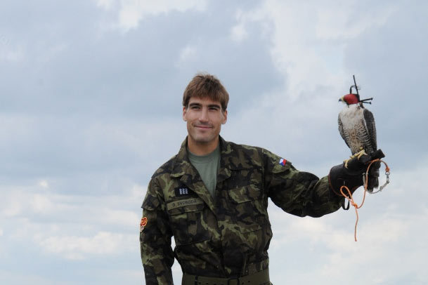 Moderní pětibojař David Svoboda drží při focení kalendáře Dukly káně, které na letišti ve Kbelích používají k plašení ptáků a další zvěře