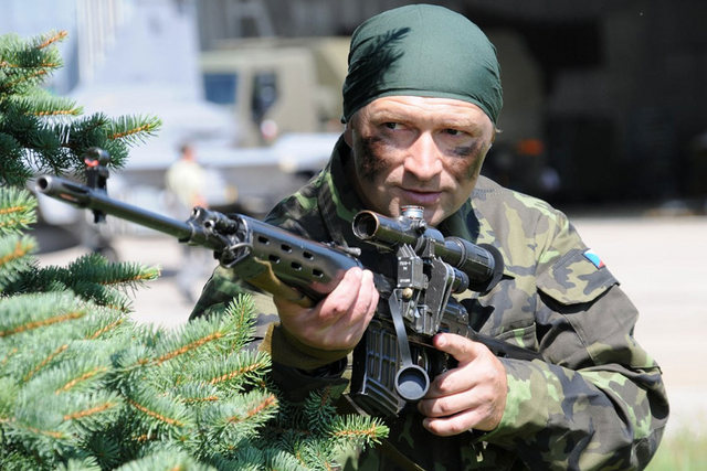 Sportovní střelec Jan Sychra v roli odstřelovače s puškou Dragunov během focení kalendáře Dukly