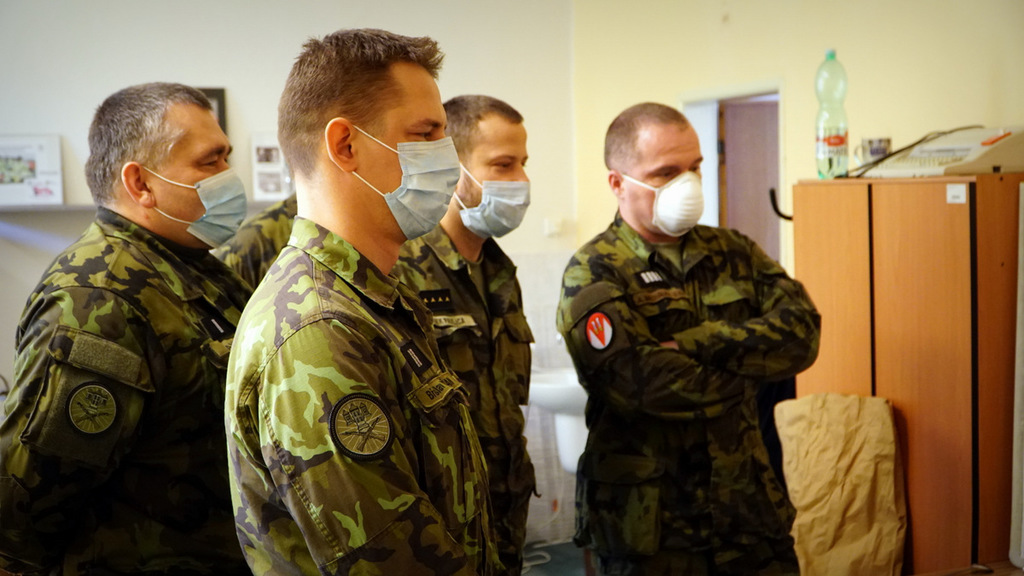 Vojáci sledují velitele, který je informuje o aktuálních úkolech. 